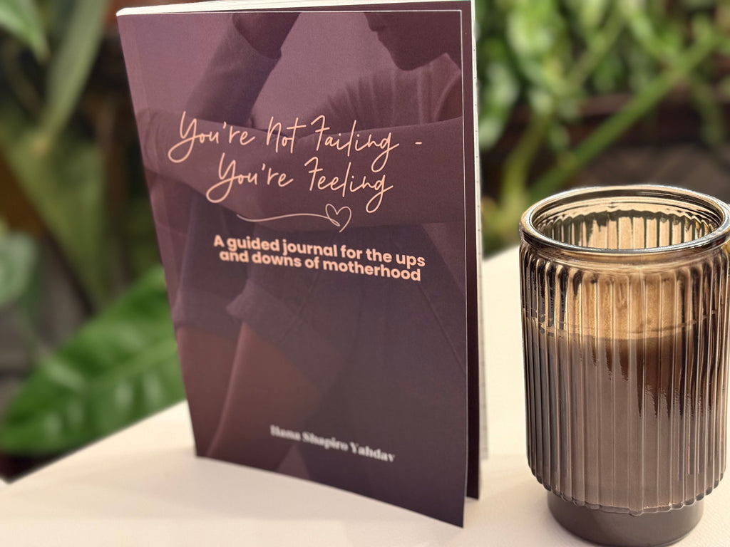 Guided journal for motherhood with a candle on a surface