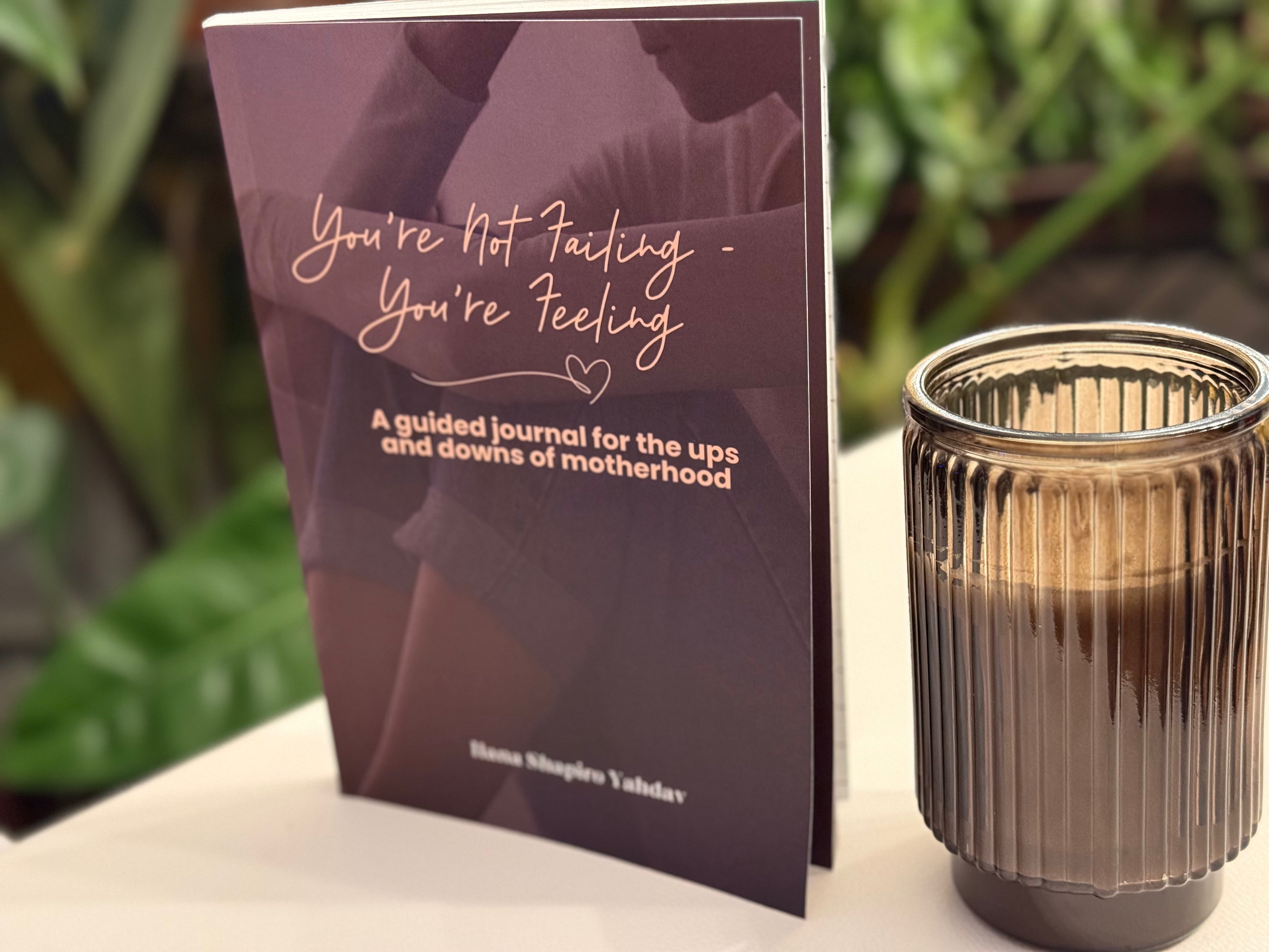 Guided journal for motherhood with a candle on a surface